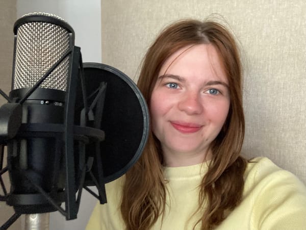 Hannah standing behing a microphone in the studio